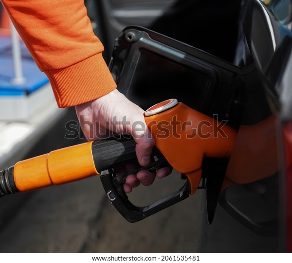 Refuel cars at the fuel pump. The\
driver hands, refuel and pump the car\'s gasoline with fuel at the\
petrol station. Car refueling at a gas station Gas\
station