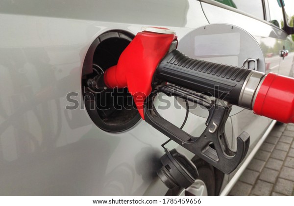 Refueling the car. The filling nozzle is\
inserted into the tank. fuel\
gasoline