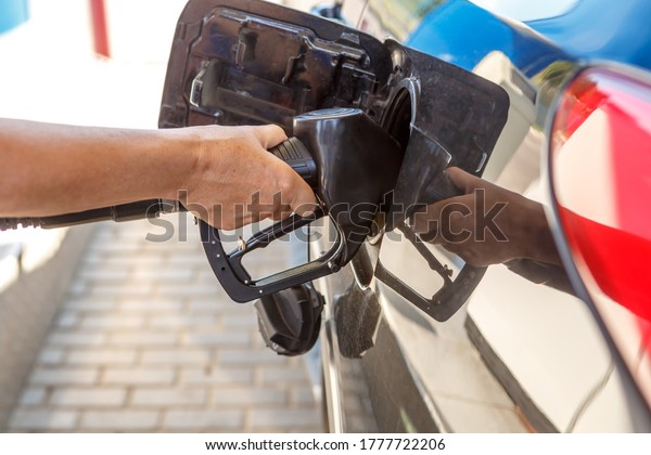 Refueling the car with fuel. Hand with refueling gun\
close up