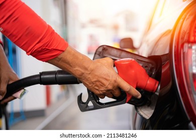 Refueling the car at a gas station fuel pump. Man driver hand refilling and pumping gasoline oil the car with fuel at he refuel station. Car refueling on petrol station. Fuel pump at station