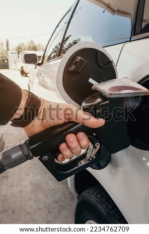 Refueling the car at a gas station fuel pump. Man driver hand refilling and pumping gasoline oil the car with fuel at he refuel station. Car refueling on petrol station. Fuel pump at station