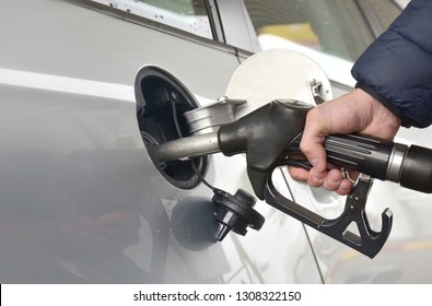 Refueling the car, grey car at gas station being filled with fuel, car refuel, copy space.