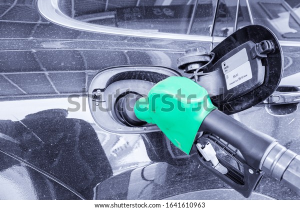 refueling a car\
on service station, oil gun\
closeup