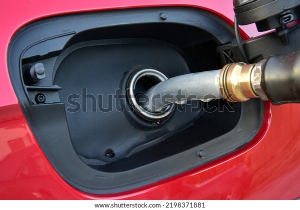 Refueling gun in tank filler. Fuel Nozzle in tank\
filler. Fuel pump in filler\
hole.