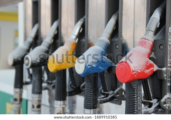 Refueling nozzles at\
a gas station covered with snow. The crisis. Economic crisis.\
Refueling the car in\
winter.
