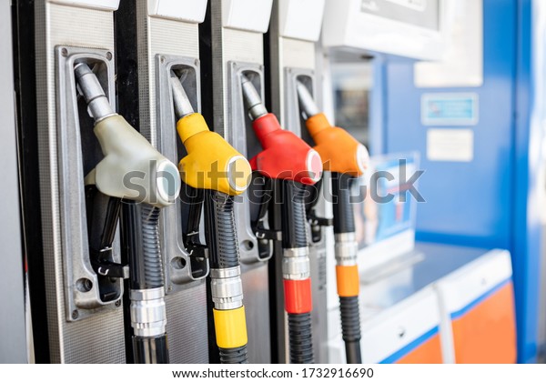 refueling pistols in\
a column at a gas\
station