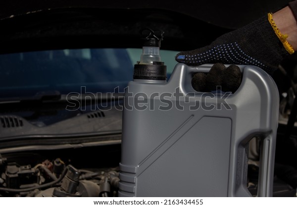 Refueling and pouring oil quality into the engine\
motor car Transmission and Maintenance Gear .Energy fuel concept.\
selective focus