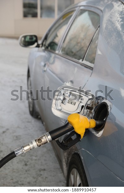 RefueRefueling gun in the gas tank of the carling\
the car in winter. Winter\
fuel.