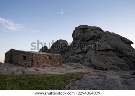 Refuge Nores in the top of The Giants rock massif in Cordoba, Argentina. View of the rocky hill, house and sky at nightfall.