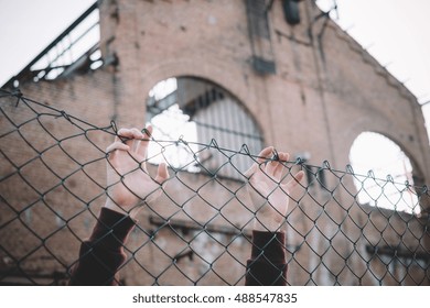 Refugee Hands Keeping Metal Fence Mesh