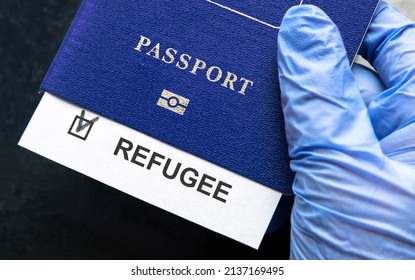 Refugee Passport In Hand At Border Control In Europe, Document With Refugee Note Close-up. Concept Of Ukraine War, Syria, EU, Humanitarian Crisis, Migration And Emigration.