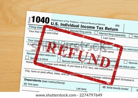 Refund message with US federal 1040 tax return form on a wood desk