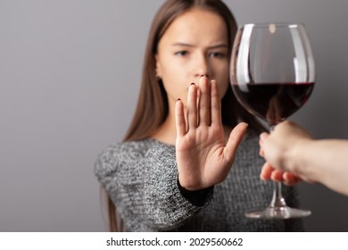 refuse alcohol, stop liquor, teenager shows a sign of rejection of wine with her hand
