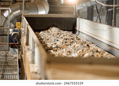 Refuse-derived fuel (RDF) on belt in an industrial recycling facility, highlighting the waste sorting and processing system used for renewable energy production. - Powered by Shutterstock