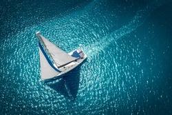 Yacht Da Regata A Vela Con Vele Bianche In Mare Aperto. Vista Aerea Della Barca A Vela In Condizioni Di Vento.