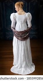 A Regency woman in a white muslin dress alone in a room