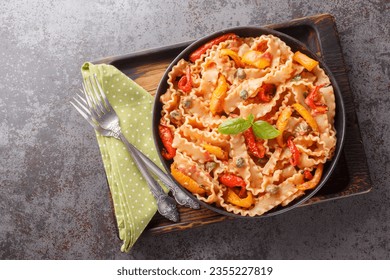 Reginette Pasta With Bell Peppers and Basil in Creamy Tomato Sauce with capers closeup on the plate on the table. Horizontal top view from above
 - Powered by Shutterstock