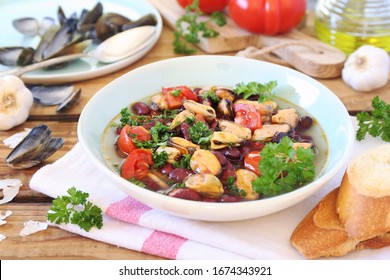 Regional Cuisine Of Italy: Southern Cuisine.  Calabria Food. Soup With Mussels, Tomatoes And Red Beans, Parsley Dressing