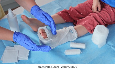 Registered Nurse Pediatrician Doctor Examining Caucasian Girl with Medical Plaster Short Leg Orthopedic Cast on After Broken Ankle Injury - Powered by Shutterstock