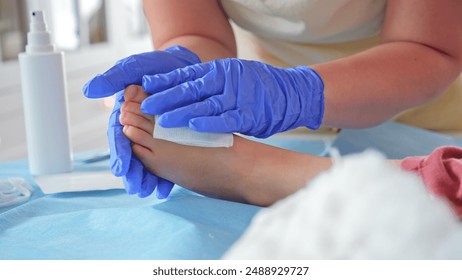 Registered Nurse Pediatritian Surgeon Doctor Treating Feet Injury Wound during Medical Procedure on Young Caucasian Girl Patient