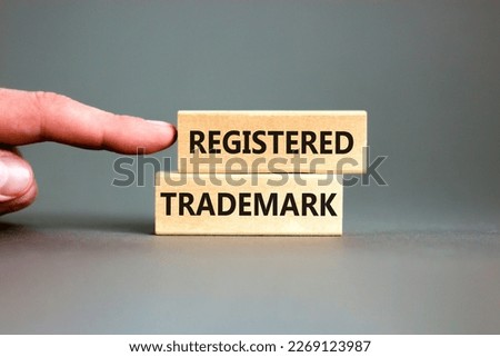 Registered trademark symbol. Concept word Registered trademark wooden blocks. Beautiful grey table grey background. Businessman hand. Business and registered trademark concept. Copy space.