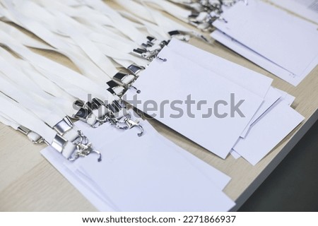 Registration desk table, process of checking in on a conference congress forum event, visitors and attendees receiving a name badge and entrance wristband bracelet and register electronic ticket
