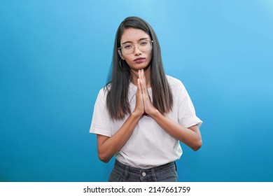 Regretful indian woman looks gloomy and desperate, keeps palms together, begs for forgiveness, feels sorry and guilty. Cute Indian asian girl pleads about something