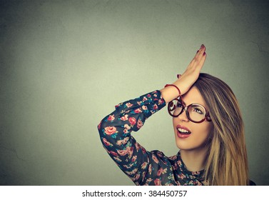 Regrets wrong doing. Closeup portrait silly young woman, slapping hand on head having duh moment isolated on gray background. Negative human emotion facial expression feeling, body language, reaction