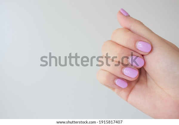 Regrown manicure. Female hand with regrown nails\
before correcting gel polish. Well-groomed hands. copy space\
trending. Place for\
text.