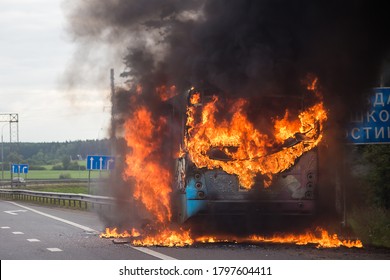 A regular bus is burning in the early morning on the highway, traffic jams on the road due to the fire