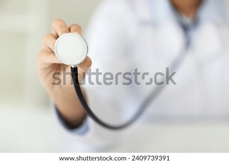 Regular checkup. Circulatory system health. Cropped of woman doctor using holding stethoscope, checking patient breath during appointment, closeup, blurred background