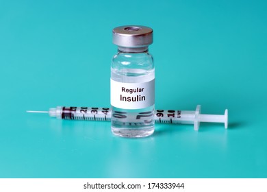 Regular insulin with syringe on aqua background. 