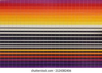 regular square wall tiles laid in horizontal stripes in shades of yellow orange beige purple and contrasting black and white