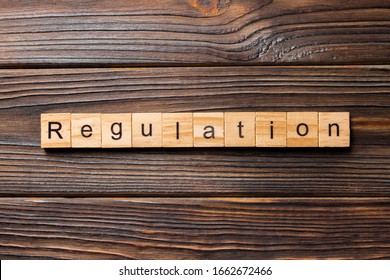 regulation word written on wood block. regulation text on table, concept. - Powered by Shutterstock