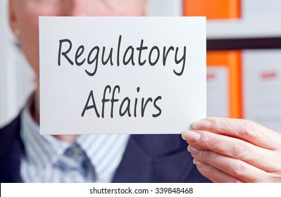 Regulatory Affairs - Businesswoman Holding Sign With Text In The Office