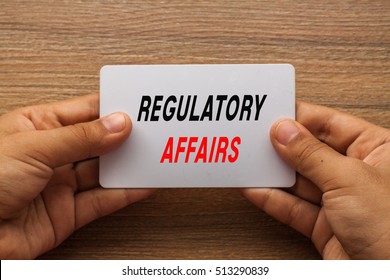 Regulatory Affairs Written On White Card Holding With Two Hands