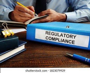 Regulatory Compliance Papers In The Folder And Manager.