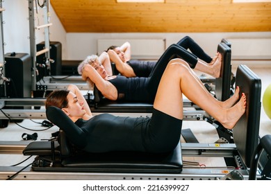 Rehabilitation and healthy lifestyle, myofascial release concept. Group of females doing abs abdomen on pilates reformer in a row at modern of studio personal workout. - Powered by Shutterstock