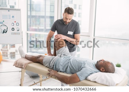 Rehabilitation therapy. Professional male therapist working in the rehabilitation center while doing the therapy