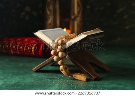 Rehal with Koran and prayer beads on grunge table