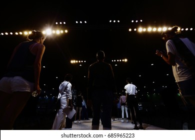 Rehearsal Of Finale Session From Many Professional Woman Models Stand Post On Ramp Stage With Full Scale Lighting On Ceiling, Shoot From Behind No Face, Low Exposure