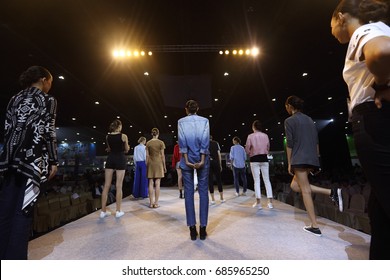 Rehearsal Of Finale Session From Many Professional Woman Models Stand Post On Ramp Stage With Full Scale Lighting On Ceiling, Shoot From Behind No Face, Low Exposure