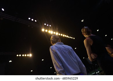 Rehearsal Of Finale Session From Professional Woman Models On Ramp Stage With Full Scale Lighting On Ceiling, Shoot From Behind No Face, Low Exposure