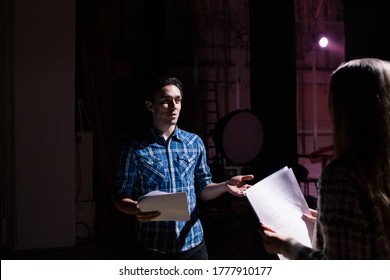 Rehearsal at theatre. Man explain to student actress how to play on the stage on the new performance for public. Dark hall at background. - Powered by Shutterstock