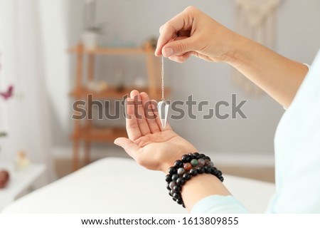 Reiki master with biolocation pendulum, closeup