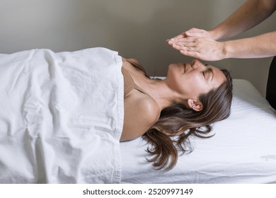 Reiki practitioner's hands transfer healing energy to young woman - Powered by Shutterstock