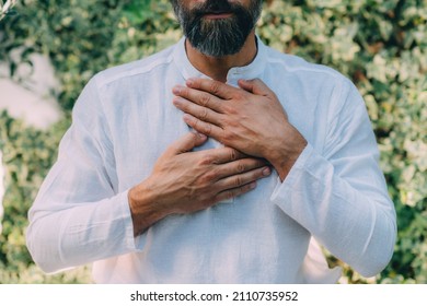 Reiki spiritual self-treatment healing session. Man holding hands above the heart chakra.   - Shutterstock ID 2110735952