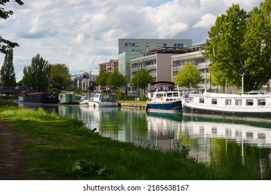 Reims, France - May 2021 - River boats berthed along the docks of Paul Doumer Boulevard, at the marina of the Vieux-Port (Old Port), on the Aisne to Marne Canal, a waterway in Champagne-Ardenne
