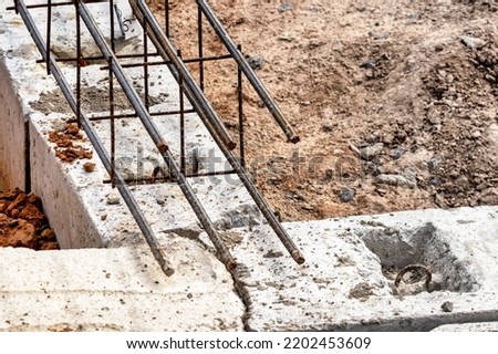 Reinforced concrete foundation of a modern monolithic residential building. Prepared formwork with reinforcing mesh for pouring concrete. Dirt and clay at the construction site