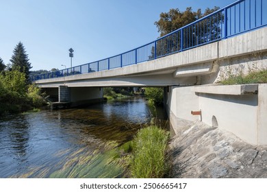 Reinforced concrete road bridge over the river. Close-up during sunny day in summer. Aerial view on a bridge across a small river. Canal or ditch with green grass meadow, Underneath of classic style  - Powered by Shutterstock